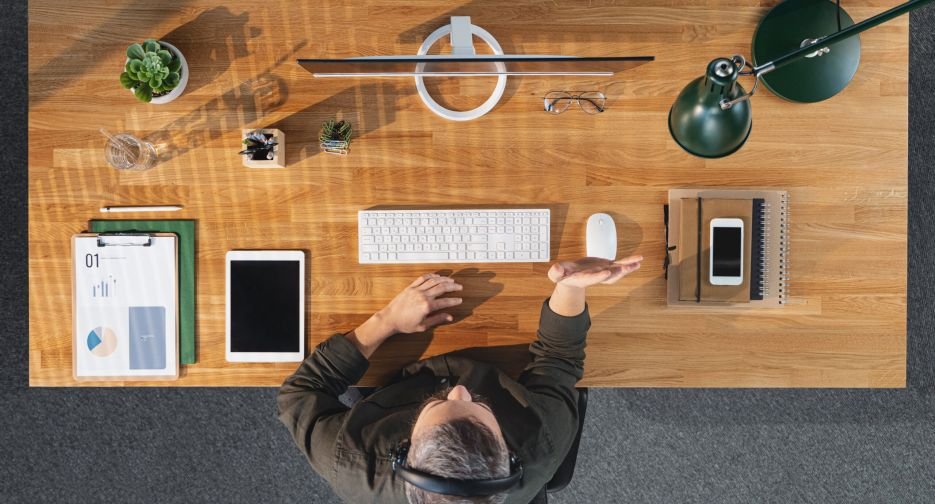 A top view of businessman working on computer at desk in home office, video call concept.